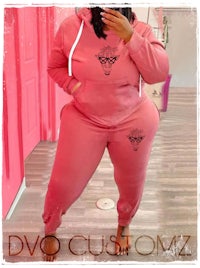 a woman wearing a pink hoodie and sweatpants